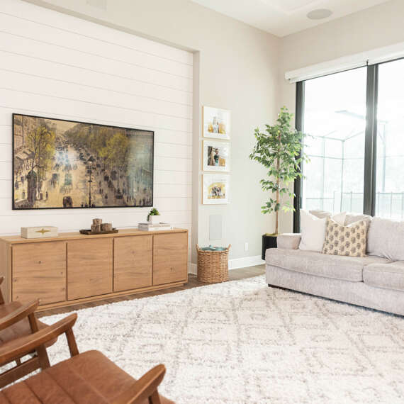 living room with large windows and white cushion and wood chairs