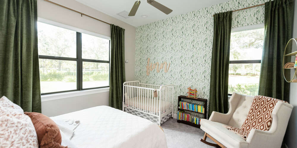 light green walls paper bedroom with ciling fan and dark green curtains