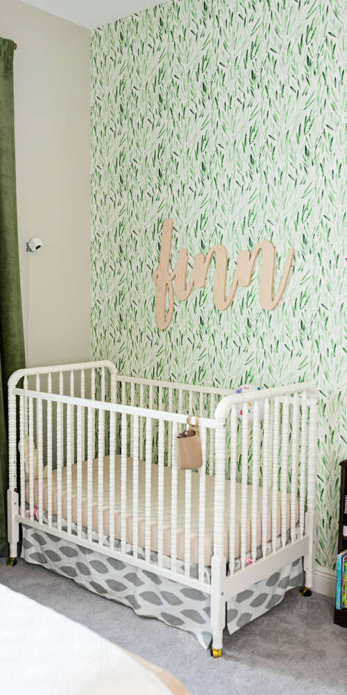 White craddle on light green paperwall bedroom