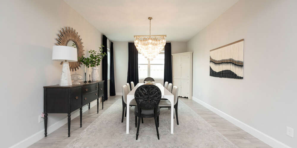 Light walls dining room-White dining table with dark chairs-dark curtains-dark furtinure-gold frame circle shape mirror-ashen wood floor-ceiling hanging lamp